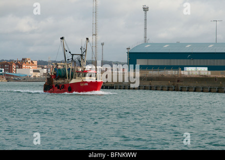 Ein Trawler Überschrift für die Hafeneinfahrt und das offene Meer. Stockfoto