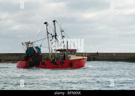 Ein Trawler Überschrift für die Hafeneinfahrt und das offene Meer. Stockfoto