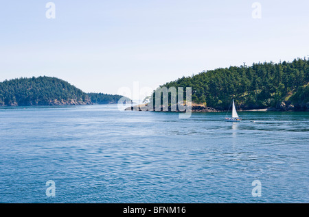 Ein Segelboot segeln in einem Kanal zwischen den Inseln in den San Juan Islands, Washington, USA. Stockfoto