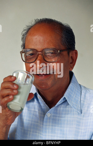 Indischer Senior Mann trinkt Milch trägt Gläser ; weißer Hintergrund ; Indien ; Asien ; MR#323 Stockfoto