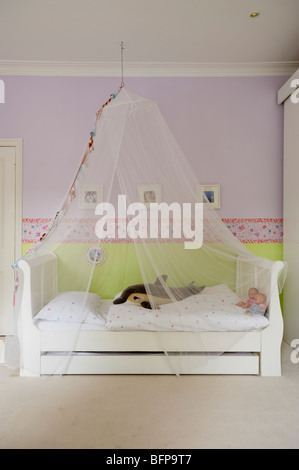 Mädchen Schlafzimmer eingerichtet in sanften Farbtönen mit einem Schmetterling-Rahmen von Designers Guild Stockfoto