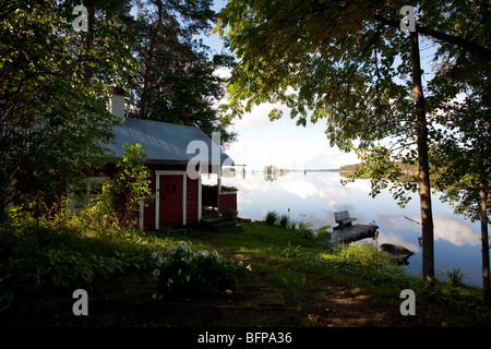 Kleine rote Holzsauna an einem See, Finnland Stockfoto