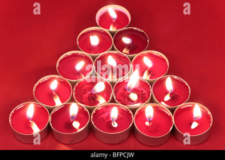 Kerzen in Baumform auf rotem Hintergrund angeordnet Stockfoto