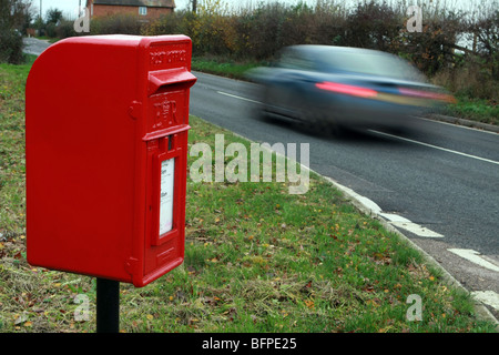 Verschwommene Datenverkehr einen ländlichen Briefkasten befindet sich auf der A28 zwischen Tenterden und Rolvenden, Kent Stockfoto