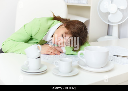 Büroangestellte ist auf Arbeit trotz betrunken durch Kaffee eingeschlafen Stockfoto