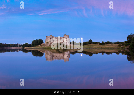 Der Mond hinter Carew Castle am Flussufer Carew Carew, Pembrokeshire, Wales Stockfoto