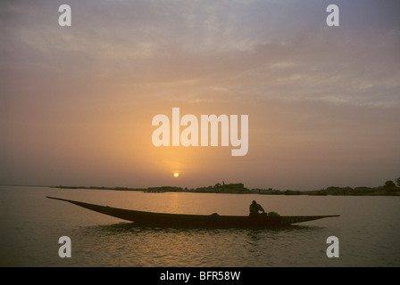 Bozo Fischer auf seinem Einbaum auf dem Niger bei Sonnenuntergang Stockfoto