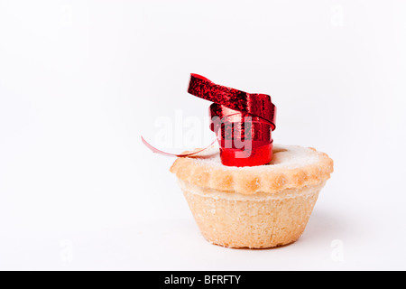 Einzelne Sweet Mince Pie isoliert vor weißem Hintergrund mit rotem Band. Stockfoto