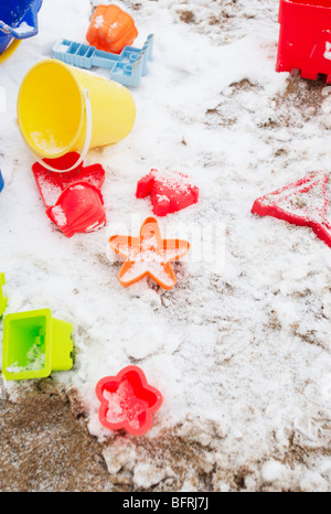 Bunte Plastikspielzeug und Neuschnee im Sandkasten Stockfoto