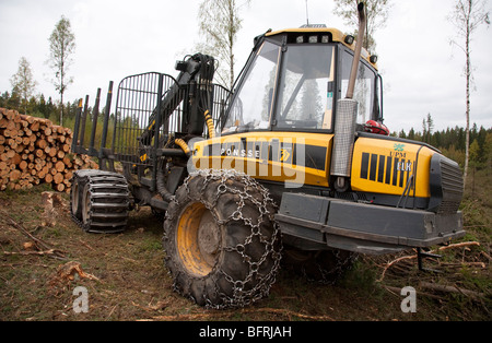 Haufen von Kiefer-Protokolle und finnischen Ponsse Elch Wald Harvester / Spediteur, Finnland Stockfoto