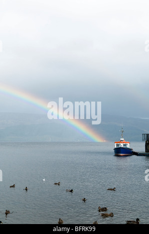 Regenbogen über Loch Lomond in Luss mit kleinen Boot im Vordergrund Stockfoto