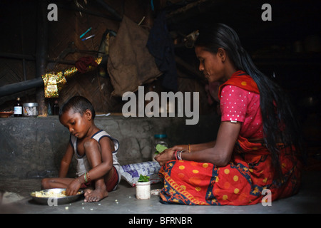 Ein Junge hat seine Mahlzeit in seiner Hütte in einem der Slums in Kolkata, Indien Stockfoto