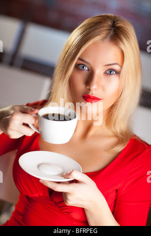 Junge Frau mit Kaffee in einem Theater. Stockfoto