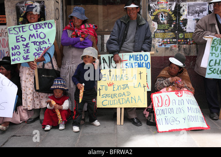 Familie Aymara steht auf Pflaster mit Plakaten bei einem marsch zum Internationalen Tag der Gewaltlosigkeit gegen Frauen (25. November) in La Paz, Bolivien Stockfoto