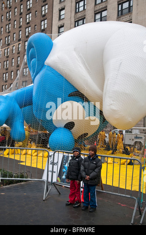 Kinder posieren vor Schlumpf Ballon gesprengt wird, für die 2009 Macy's Thanksgiving Day Parade Stockfoto