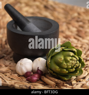 Knoblauch, Zwiebeln und Artischocken mit Mörser und Stößel Stockfoto