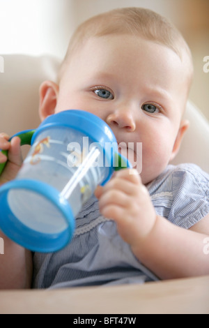 Babymädchen mit Sippy Cup Stockfoto