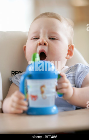 Babymädchen in einen Hochstuhl zu gähnen Stockfoto