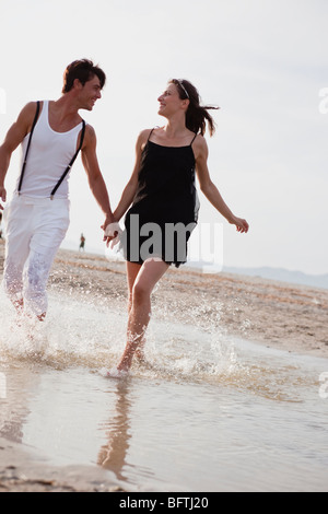 paar am Strand entlang laufen Stockfoto