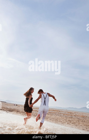 paar am Strand entlang laufen Stockfoto