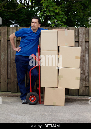 Man liefert Boxen auf Wagen Stockfoto