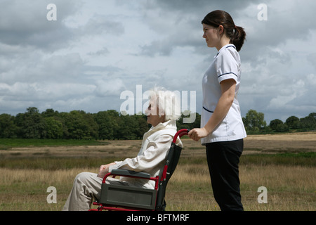 Ältere Frau im Rollstuhl mit Krankenschwester Stockfoto