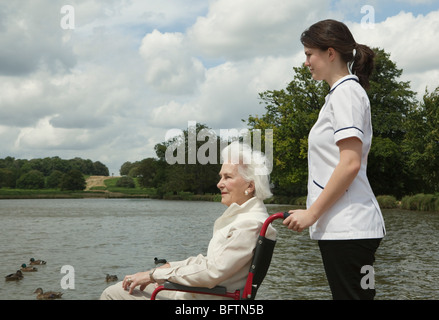 Ältere Frau im Rollstuhl mit Krankenschwester Stockfoto