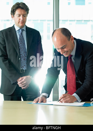 Geschäftsmann, die Unterzeichnung der Papiere mit partner Stockfoto