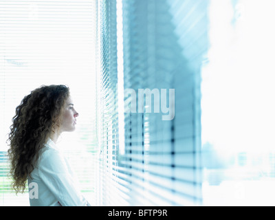 Business-Frau Blick durch Fenster Stockfoto