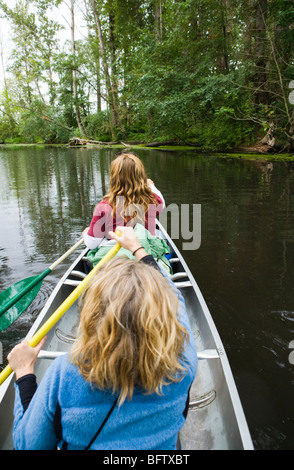 Zwei Frauen paddeln Kanu in der Washington State University Arboretum in Seattle, Washington, USA. Stockfoto
