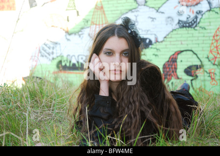 junge Frau posiert vor Graffitiwand Stockfoto