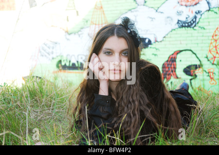 junge Frau posiert vor Graffitiwand Stockfoto