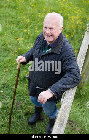 Landwirt stützte sich auf Zaun Stockfoto