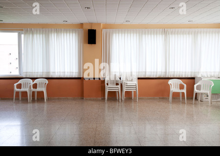 leeren Raum mit Plastikstühlen an der Wand Stockfoto
