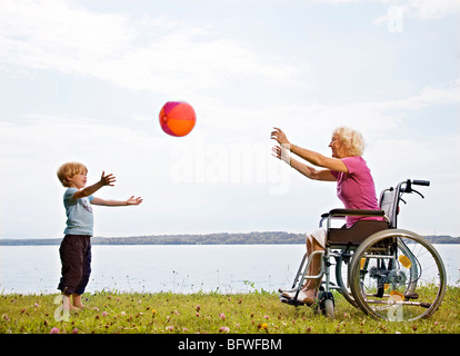 Jungen spielen Ball mit älteren Frau Stockfoto