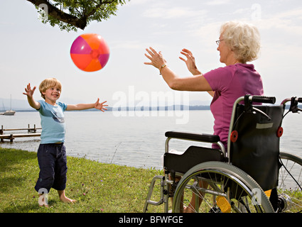 Jungen spielen Ball mit älteren Frau Stockfoto