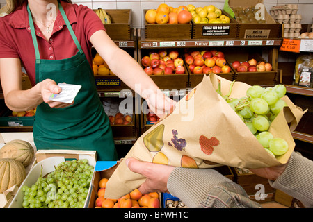 Man bezahlte Ladenbesitzer für Obst Stockfoto