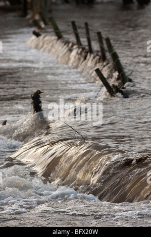 Überfluteten Ackerland zeigt Großballen und Zäune beschädigt Stockfoto