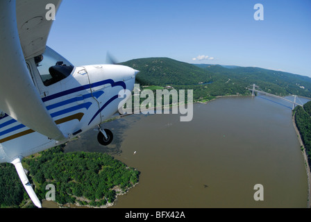 Ein Licht Flugzeug Cessna 172 fliegen über Hudson River in der Nähe von Bear Mountain Bridge Road und Iona Insel, Staat New York, USA Stockfoto