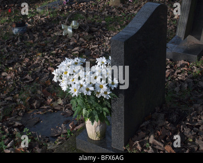 Blumen auf ein Grab auf einem Friedhof Stockfoto