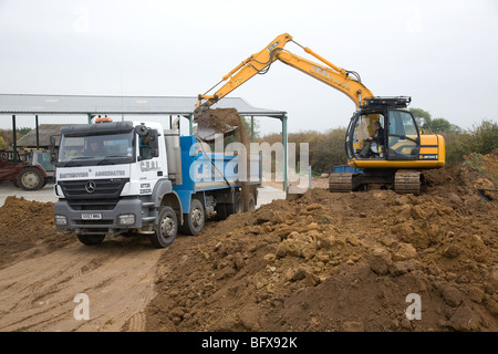 Ein 360 Digger laden Boden in einem LKW Stockfoto