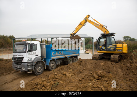 Ein 360 Digger laden Boden in einem LKW Stockfoto