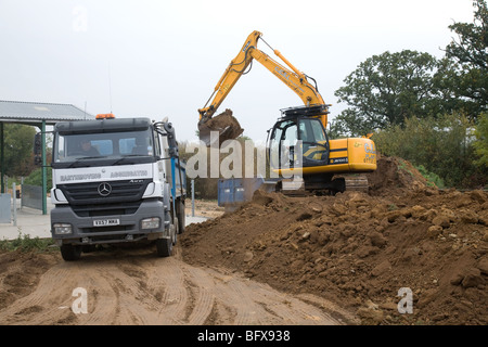 Ein 360 Digger laden Boden in einem LKW Stockfoto