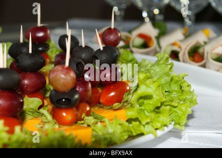 Teller mit frischen Häppchen auf einer weißen Tischdecke Stockfoto