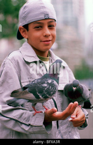 Young Boy Fütterung Vögel, Kind hält Tauben, Granville Island, Vancouver, BC, Britisch-Kolumbien, Kanada Stockfoto