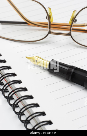 Brille und Füllfederhalter auf Schreibblock Stockfoto