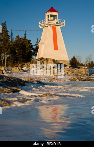 South Bay Lighthouse spiegelt sich in Eisbildung entlang Georgian Bay Küste, South Bay, Manitoulin Island, Ontario, Kanada Stockfoto