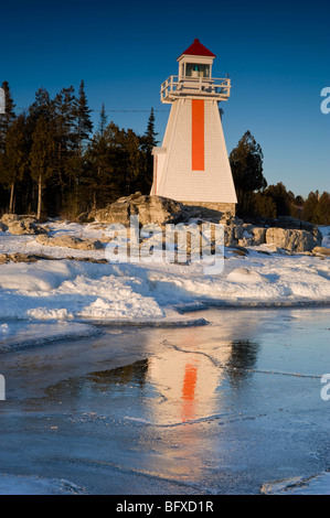 South Bay Lighthouse spiegelt sich in Eisbildung entlang Georgian Bay Küste, South Bay, Manitoulin Island, Ontario, Kanada Stockfoto