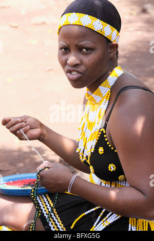 Traditionelle Perlen gekleidet eines Zulu jungen Erwachsenen afrikanischen Mädchens tun Sicke, KwaZulu Natal, Südafrika, November 2009 Stockfoto