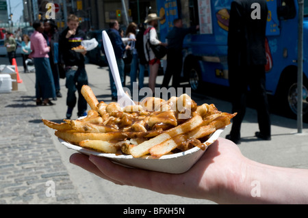 Eine Umhüllung von POUTINE - Pommes frites, Quark und Soße - von einem Straßenrand chip Lkw in der Innenstadt von Toronto, Ontario, Kanada. Stockfoto